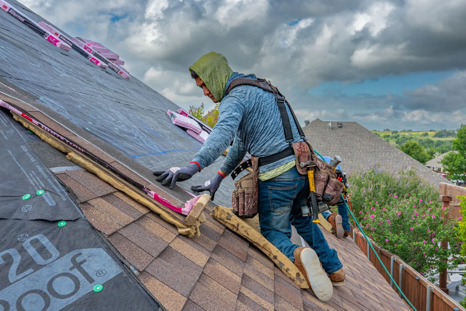 Profissional instalando telhas shingle sobre a subcobertura